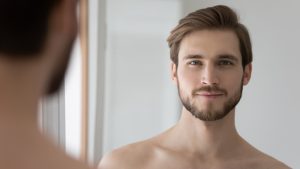 Man looking in the mirror after skin cancer reconstruction in Mount Vernon, WA